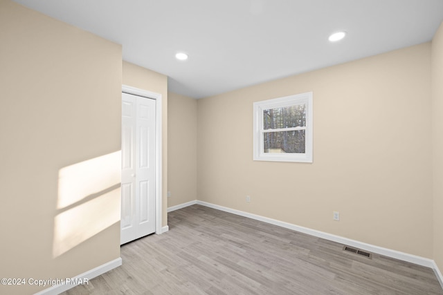 unfurnished bedroom with recessed lighting, visible vents, baseboards, and wood finished floors