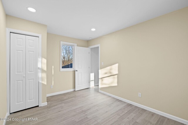 410 Sunset Forest Dr, Hawley, PA 18428 - unfurnished bedroom with wood finished floors, baseboards, a closet, and recessed lighting