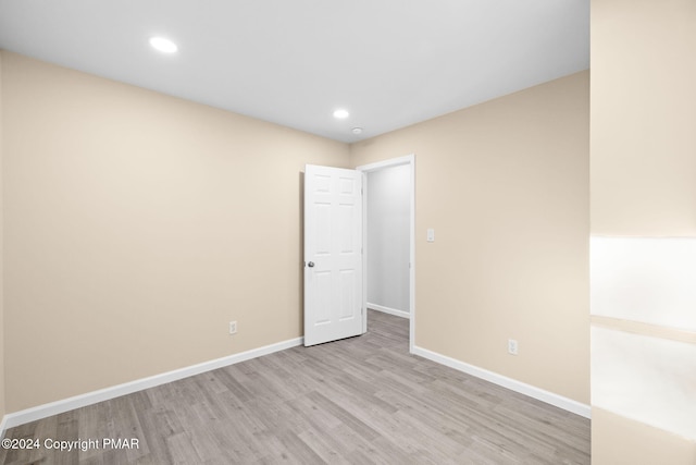 spare room featuring baseboards, wood finished floors, and recessed lighting