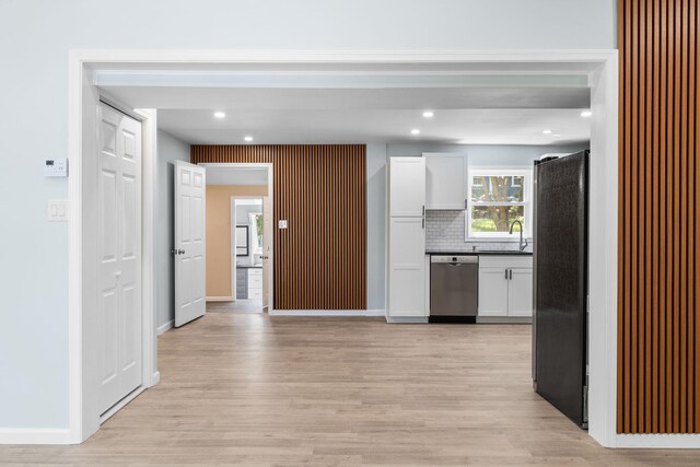 410 Sunset Forest Dr, Hawley, PA 18428 - kitchen with stainless steel appliances, white cabinetry, light wood-style floors, a sink, and backsplash