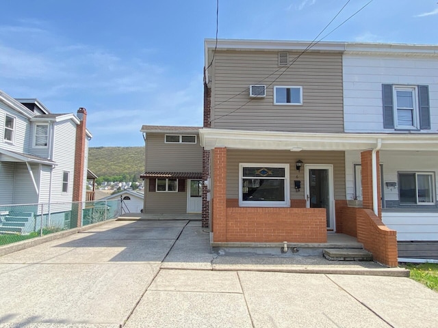 multi unit property featuring a porch, fence, and concrete driveway