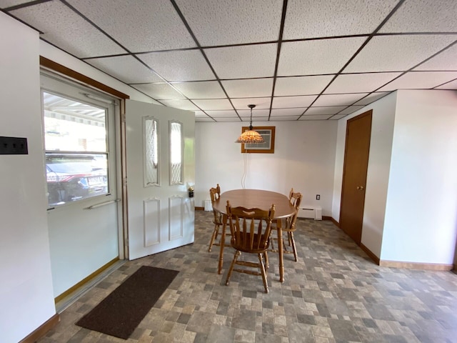 dining room featuring baseboards, a paneled ceiling, a baseboard heating unit, and visible vents