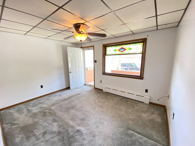unfurnished bedroom with carpet floors, baseboard heating, and a paneled ceiling