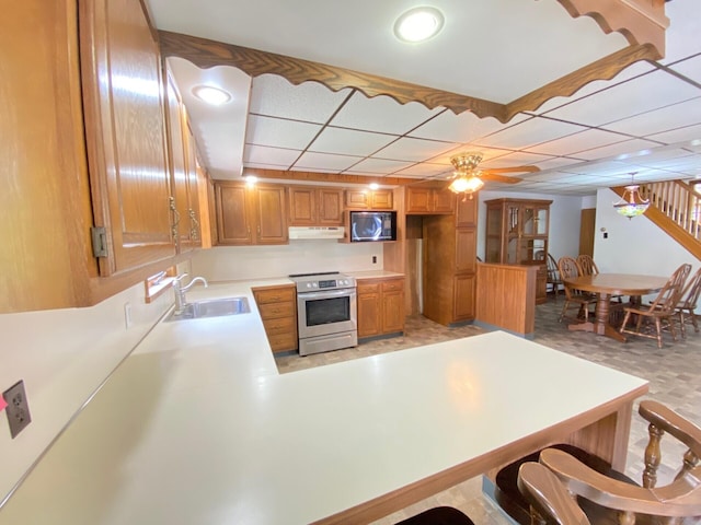 kitchen with black microwave, light countertops, under cabinet range hood, a sink, and stainless steel electric range oven