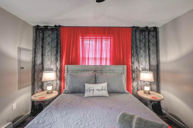 bedroom featuring baseboards and electric panel