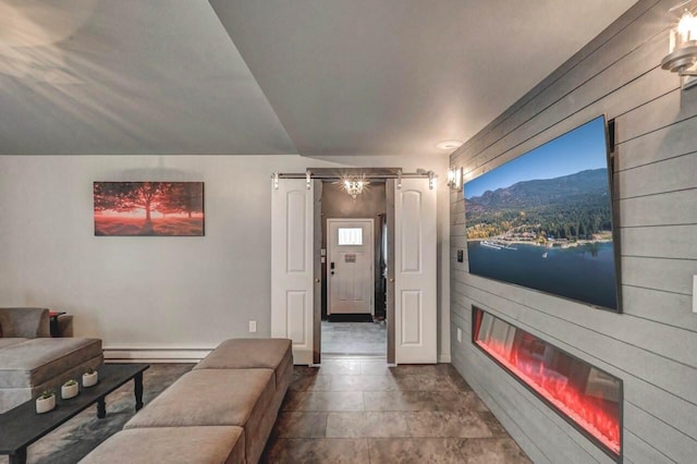 living room with a baseboard radiator, a large fireplace, and baseboards