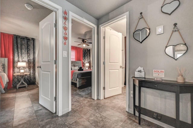 hallway featuring baseboards and tile patterned flooring