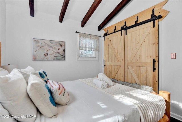 bedroom with vaulted ceiling with beams and a barn door