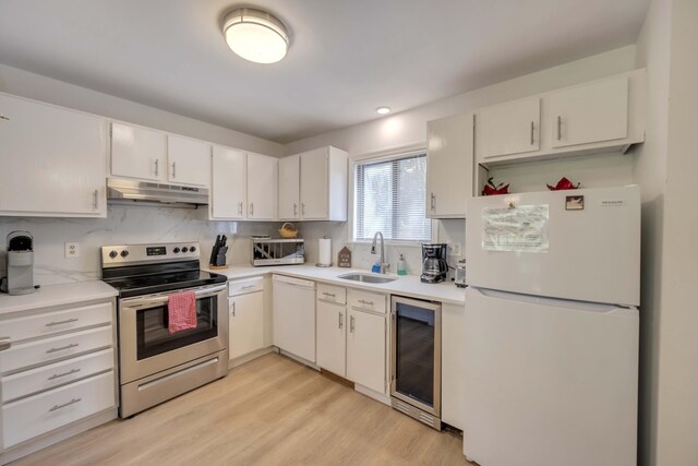 130 Cross Country Ln, Tannersville, PA 18372 - kitchen featuring white appliances, under cabinet range hood, beverage cooler, a sink, and light countertops