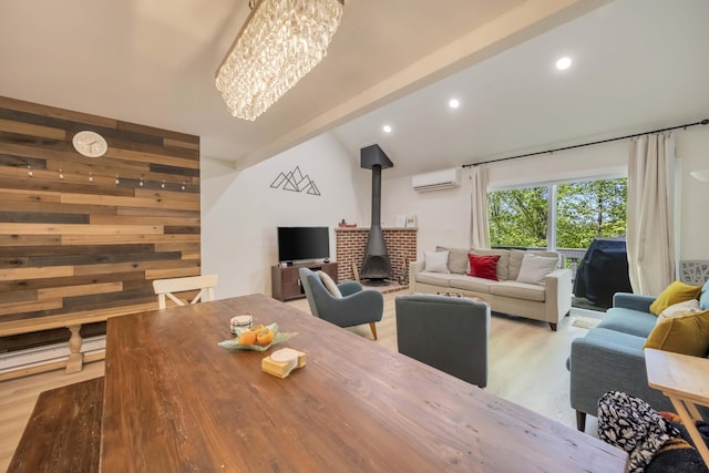 130 Cross Country Ln, Tannersville, PA 18372 - living room featuring a wall unit AC, wood finished floors, a wood stove, a chandelier, and lofted ceiling