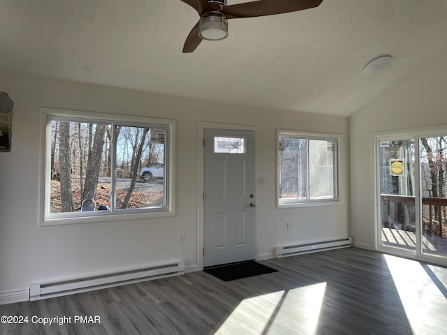 foyer entrance with baseboard heating, wood finished floors, a ceiling fan, and vaulted ceiling