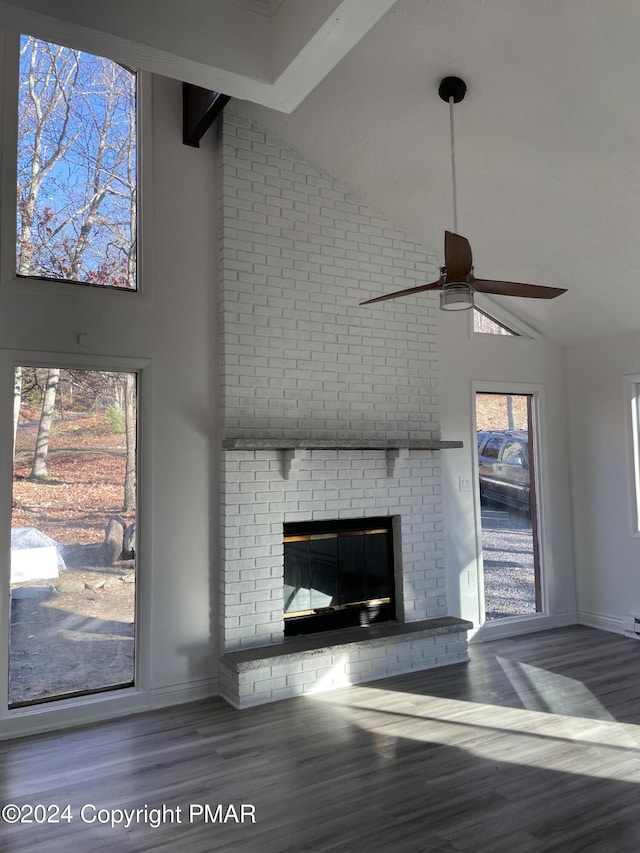 unfurnished living room with a fireplace, high vaulted ceiling, wood finished floors, and ceiling fan