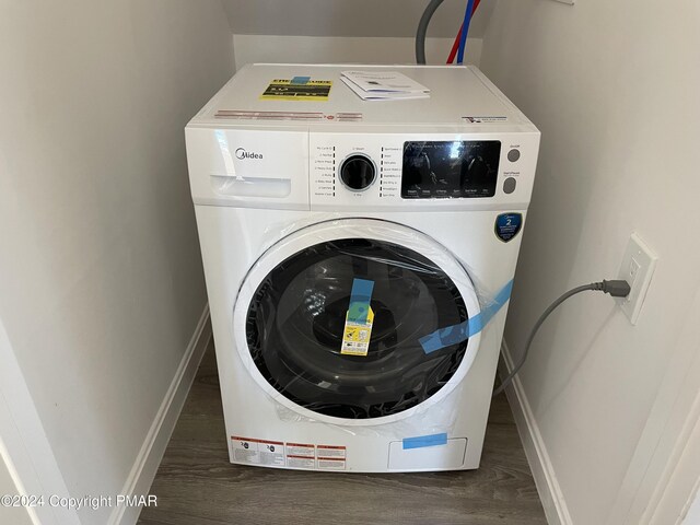 laundry room with laundry area, washer / clothes dryer, wood finished floors, and baseboards