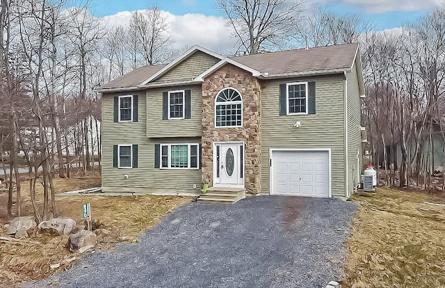 colonial home featuring driveway, stone siding, roof with shingles, an attached garage, and central AC unit