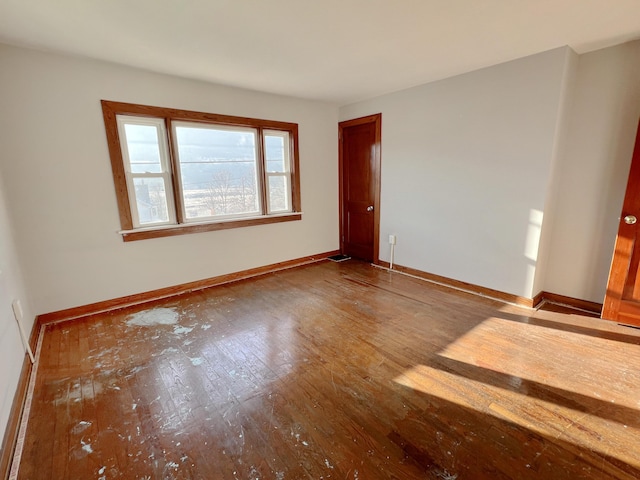 spare room with hardwood / wood-style floors and baseboards