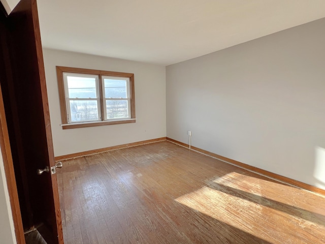 unfurnished room with wood-type flooring and baseboards