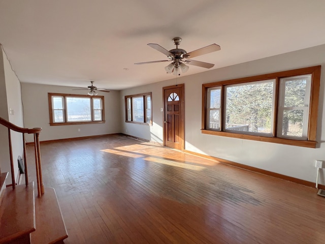 interior space with stairs, hardwood / wood-style floors, a ceiling fan, and baseboards