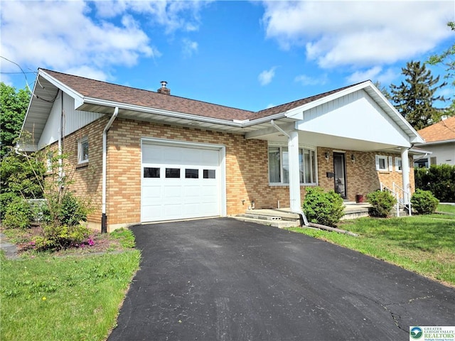 view of front of property featuring an attached garage, brick siding, covered porch, and asphalt driveway
