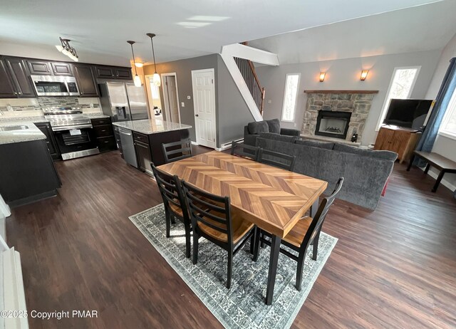 dining area with a fireplace, dark wood-type flooring, and sink