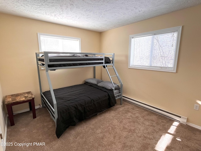 carpeted bedroom with baseboard heating and a textured ceiling