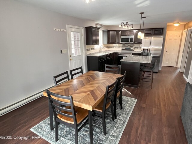 dining room with sink, a baseboard radiator, and dark hardwood / wood-style floors