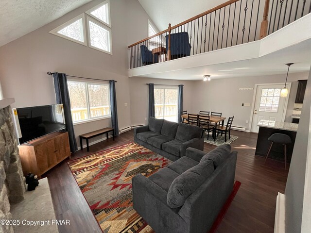 living room with dark wood-type flooring, high vaulted ceiling, and a textured ceiling