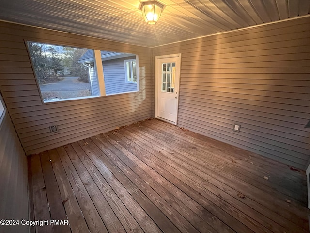 unfurnished room featuring wood ceiling and wooden walls