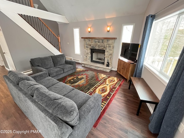 living room with dark hardwood / wood-style flooring, a baseboard heating unit, vaulted ceiling, and a fireplace