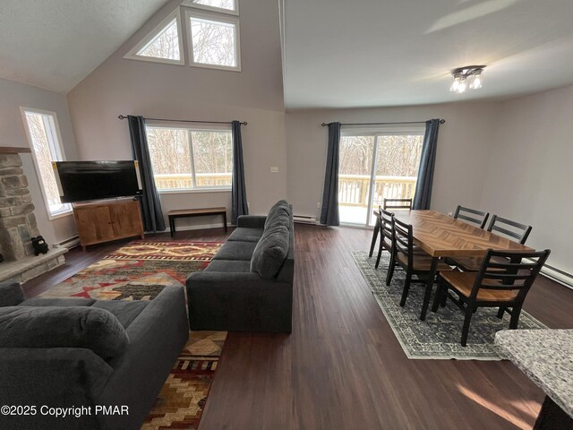 living room featuring baseboard heating, dark hardwood / wood-style floors, and a wealth of natural light