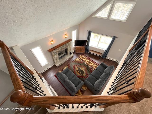 living room with a healthy amount of sunlight, a stone fireplace, and vaulted ceiling