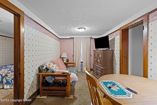 carpeted bedroom featuring wallpapered walls and a textured ceiling