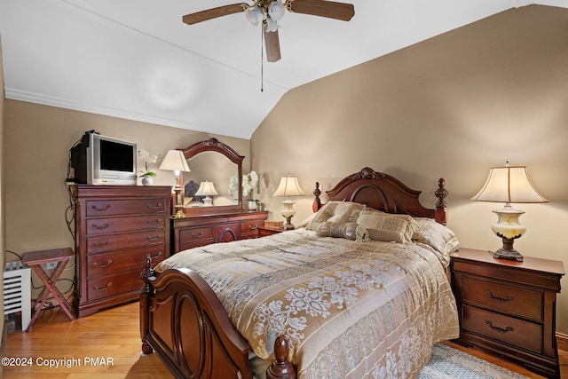 bedroom with vaulted ceiling, light wood-style flooring, and ceiling fan