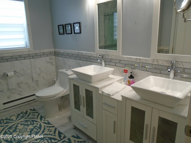 bathroom featuring marble finish floor, baseboard heating, a sink, and toilet