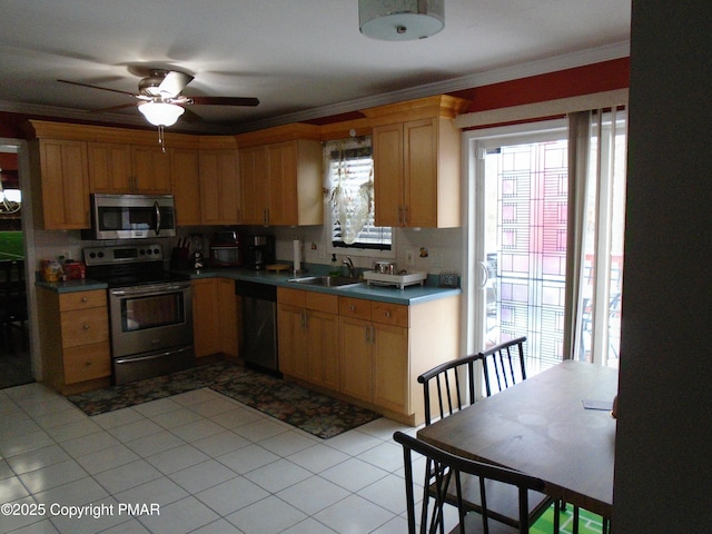 kitchen with crown molding, stainless steel appliances, sink, and light tile patterned floors