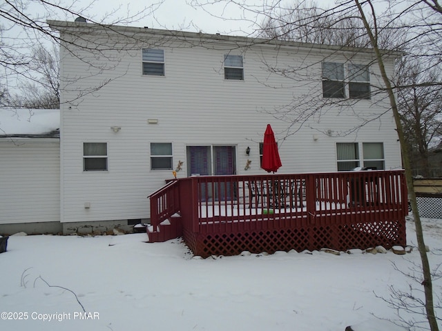 snow covered house featuring a wooden deck