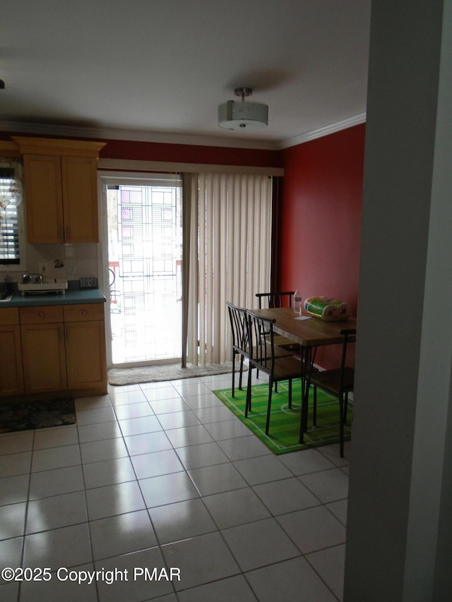 dining room with light tile patterned floors and crown molding