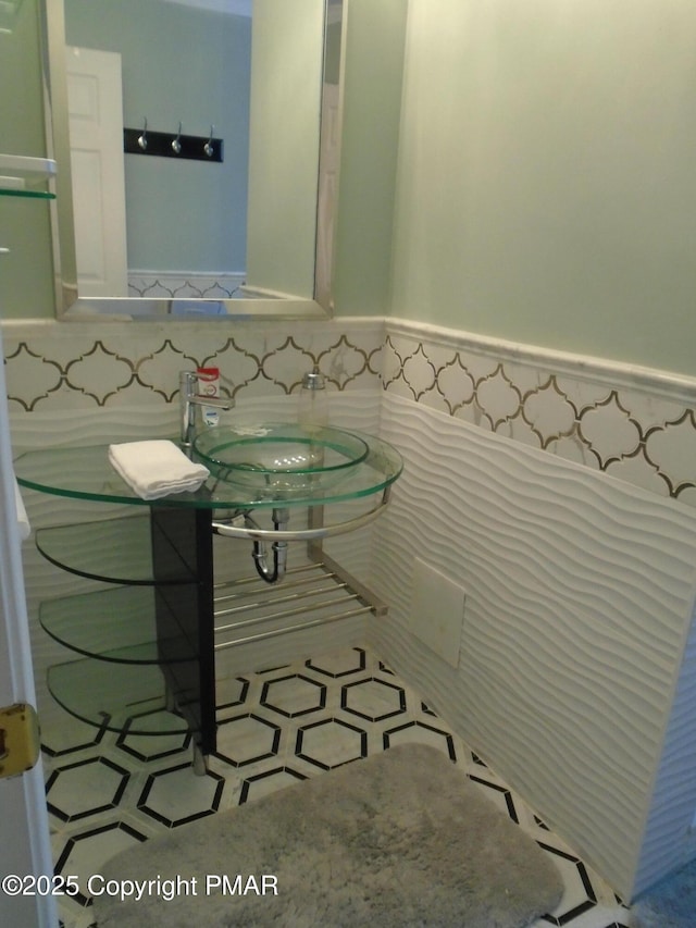 bathroom featuring sink and tile walls