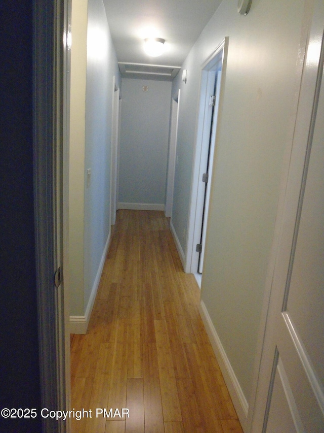 hall featuring light wood-type flooring and baseboards