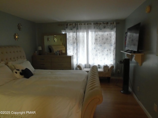 bedroom featuring baseboards and wood finished floors