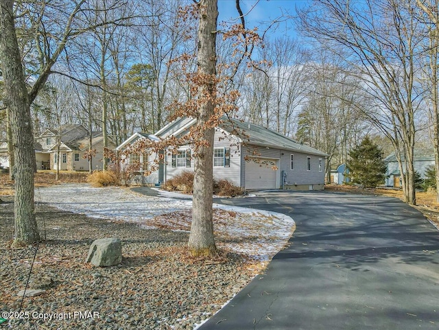 view of home's exterior featuring a garage and aphalt driveway