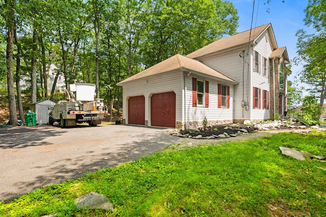 60 Arbutus Ln, East Stroudsburg, PA 18302 - view of side of property featuring driveway, a garage, and a shed