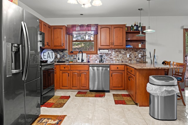 60 Arbutus Ln, East Stroudsburg, PA 18302 - kitchen with black appliances, a peninsula, brown cabinetry, light stone countertops, and backsplash