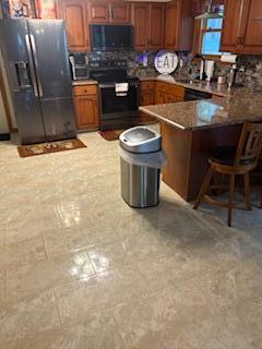 60 Arbutus Ln, East Stroudsburg, PA 18302 - kitchen with black appliances, brown cabinets, a breakfast bar area, and a peninsula