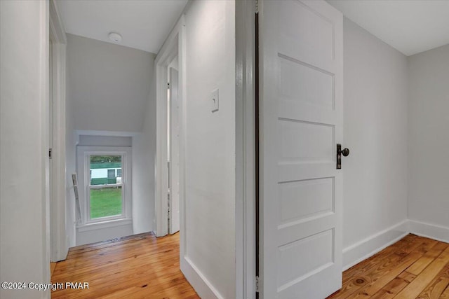 hall featuring light wood finished floors and baseboards
