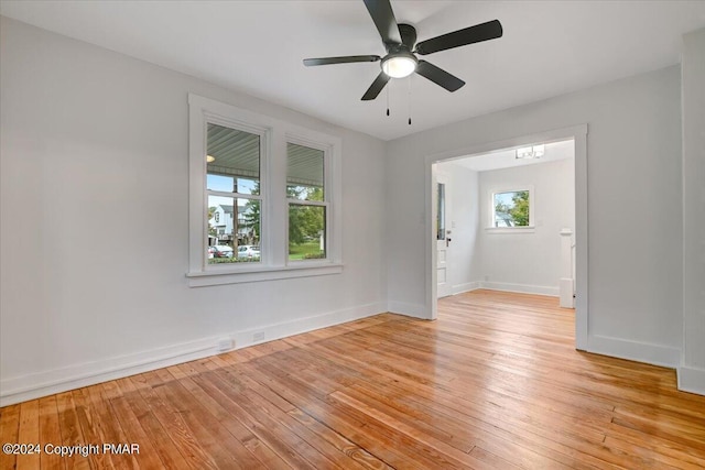 unfurnished room featuring light wood finished floors, a ceiling fan, and baseboards
