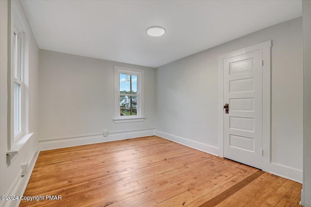 spare room with light wood-style flooring and baseboards