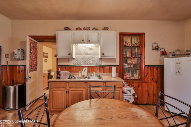 3310 Hazen Ave, Roseto, PA 18013 - kitchen with light wood finished floors, a wainscoted wall, freestanding refrigerator, wood walls, and a sink