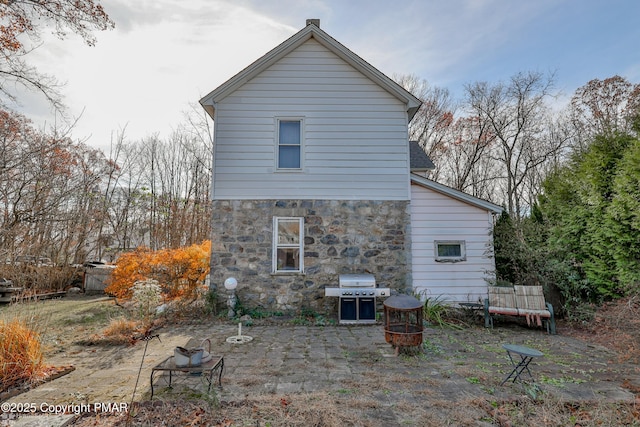 3310 Hazen Ave, Roseto, PA 18013 - rear view of house with stone siding, a fire pit, and a patio