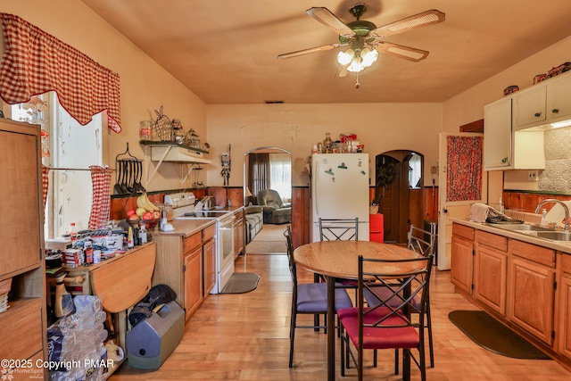 3310 Hazen Ave, Roseto, PA 18013 - kitchen featuring arched walkways, electric range oven, freestanding refrigerator, light wood-type flooring, and a sink