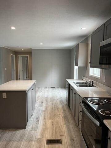 132 Spruce St, Greentown, PA 18426 - kitchen featuring stainless steel microwave, a sink, light wood-style floors, black / electric stove, and a kitchen island